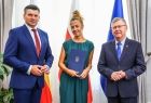 Kobieta w zielonej sukience z członkami zarządu.
