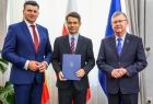 Mężczyzna w czarnym garniturze z członkami zarządu.