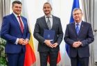 Mężczyzna trzymający teczkę w dłoniach z członkami zarządu.