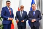 Mężczyzna w granatowym garniturze z członkami zarządu.