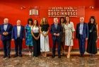 Zdjęcie grupowe na tle czerwonej ściany z logotypem Małopolskiej Szkoły Gościnności.