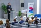 Marszałek Łukasz Smółka mówi przy mównicy na scenie.