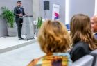 Marszałek Łukasz Smółka mówi przy mównicy na scenie do mikrofonu.