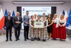 Uczestnicy wydarzenia stoją na scenie.