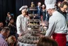 Widok na tort okolicznościowy z okazji 39 urodzin Teatru Witkacy - po bokach cukiernicy w tradycyjnych strojach