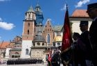Strażacy z sztandarami na tle Wawelu.