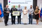 Uczestnicy wydarzenia stoją na scenie.