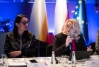 Dwie kobiety przy stole. W tle flagi Małopolski, Polski i Unii Europejskiej.