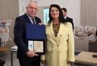 Wicemarszałek Ryszard Gawron stoi z kobietą w żółtej marynarce.