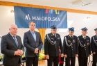 Wicemarszałek Ryszard Pagacz stoi ze strażakami.