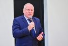 Wicemarszałek Ryszard Pagacz stoi i trzyma mikrofon.