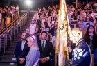 Wicemarszałek Łukasz Smółka siedzi na widowni. Przed nim widoczny poczet sztandarowy.