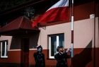 Strażacy wciągają flagę Polski na maszt.