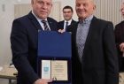 Wicemarszałek Ryszard Gawron stoi z mężczyzną i wyróżnieniem.