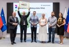 Uczestnicy wydarzenia stoją na scenie.