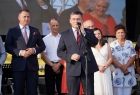 Wojciech Skruch stoi na scenie. Za nim widoczni inni ludzie.