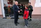 Wicemarszałek Ryszard Pagacz rozmawia z małym strażakiem.