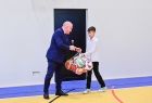 Wicemarszałek Ryszard Pagacz przekazuje chłopcu piłkę.