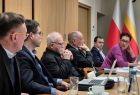 Uczestnicy posiedzenia siedzą przy stole.