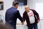 Wicemarszałek Łukasz Smółka podaje rękę mężczyźnie.