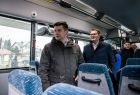 Wicemarszałek Łukasz Smółka ogląda wnętrze autobusu.