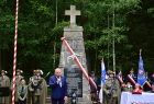 Wicemarszałek Ryszard Pagacz stoi przed pomnikiem. Obok żołnierze.