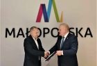 Wicemarszałek Ryszard Pagacz podaje rękę mężczyźnie. Za nimi widoczne logo Małopolska.
