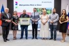 Uczestnicy wydarzenia stoją na scenie.