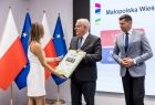 Wicemarszałek Ryszard Pagacz wręcza kobiecie nagrodę. Obok stoi marszałek Łukasz Smółka.