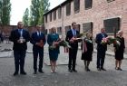 Iwona Gibas z zarządu województwa wraz prezydentem Oświęcimia Januszem Chwierutem, starostą oświęcimskim Andrzejem Skrzypińskim oraz oświęcimskimi samorządowcami składa kwiaty przed Ścianą Śmierci w byłym niemieckim obozie koncentracyjnym Auschwitz 