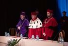 Kadra profesorska stoi na scenie.