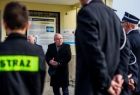 Wicemarszałek Pagacz stoi przed remizą. Przed nim stoją strażacy.