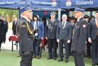Strażacy stoją naprzeciw siebie. Z tyłu widoczny wicemarszałek Łukasz Smółka stojący pod namiotem z innymi ludźmi.