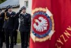 Wicemarszałek Łukasz Smółka salutuje przed sztandarem.