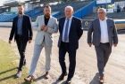 Wicemarszałek Ryszard Pagacz idzie po stadionie. Obok inni mężczyźni.