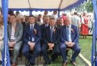 Wicemarszałek Ryszard Pagacz siedzi pod namiotem z innymi ludźmi.