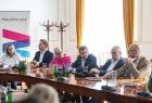 Ludzie siedzą przy stole.