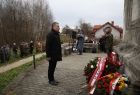 Arkadiusz Wrzoszczyk stoi przed pomnikiem.