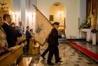 Poczet sztandarowy Sybiraków idzie przez kościół.