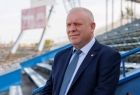 Wicemarszałek Ryszard Pagacz stoi na trybunie stadionu.