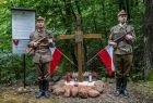 Żołnierze stoją na warcie obok krzyża.
