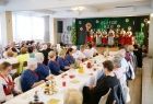 Uczestnicy jubileuszu zasiadający przy stołach ustawionych przed sceną