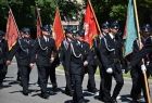 Strażacy ze sztandarami w marszu.