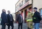 Wicemarszałek Ryszard Pagacz wraz z innymi ludźmi ogląda fasadę remizy.