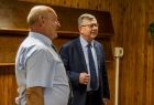 Wicemarszałek Witold Kozłowski rozmawia z mężczyzną, za nimi widoczna drewniana ściana.