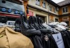 Strażackie ubrania i buty leżą przed wozem strażackim.