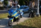 Motocykl policyjny stoi na chodniku.