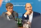 Dwóch mężczyzn siedzą przy stole.