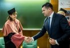 Wicemarszałek Łukasz Smółka ściska dłoń pani profesor.