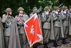 Żołnierze trzymają sztandar.